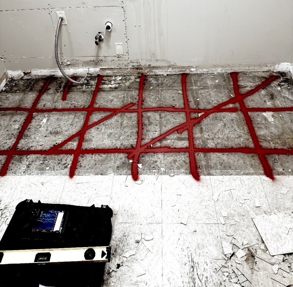 Photo of concrete floor with markings from GPR discovery.